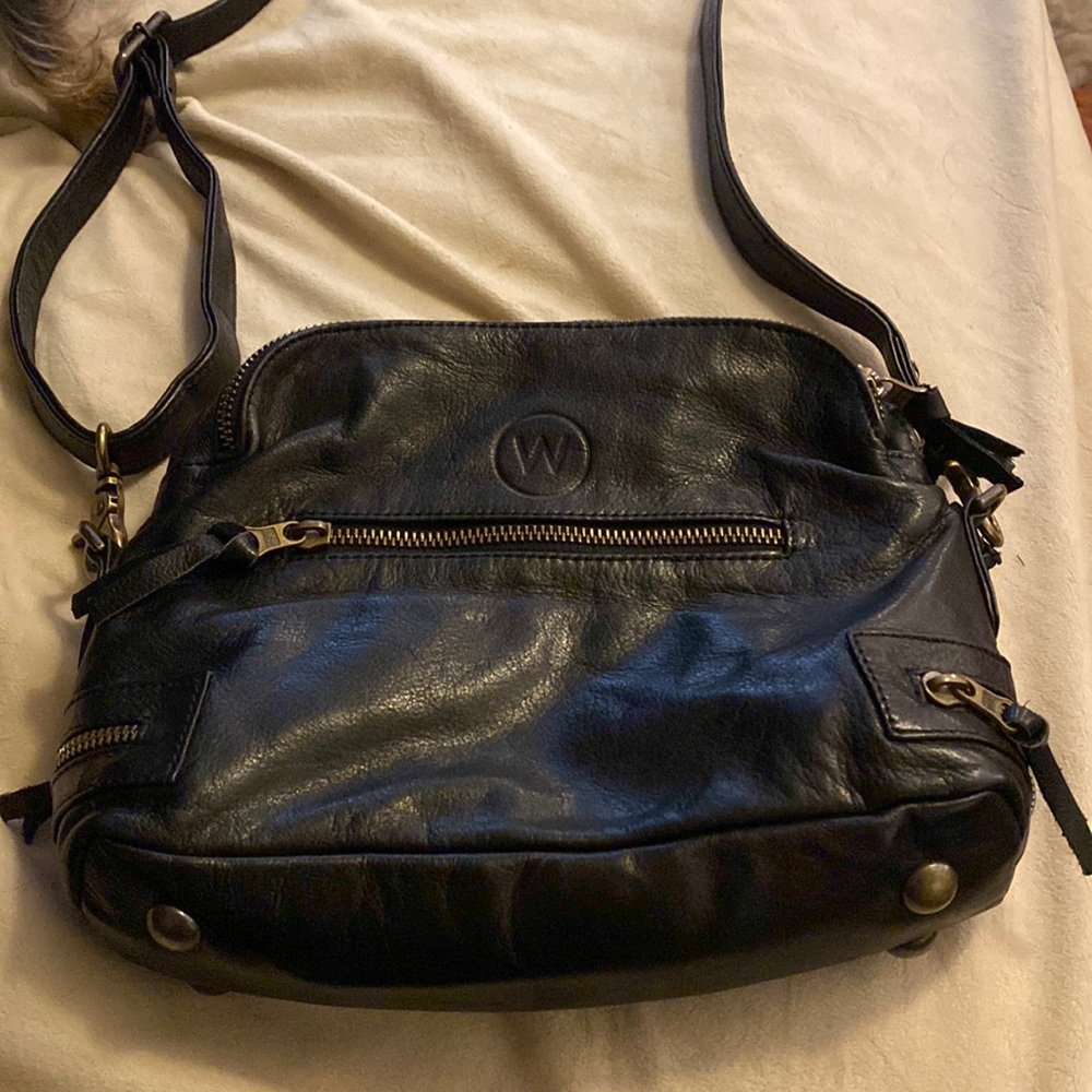 Black wanderer handbag made in Australia. Adjusts to crossbody shoulder or hand.
